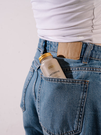 Made To Lactate LactaVive bottle carried in the back pocket of blue jeans